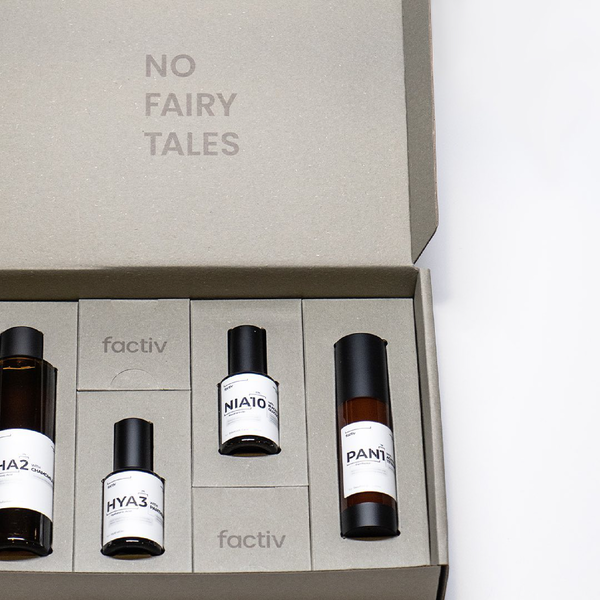 Inside a colorful mailing box are four bottles of different sizes.