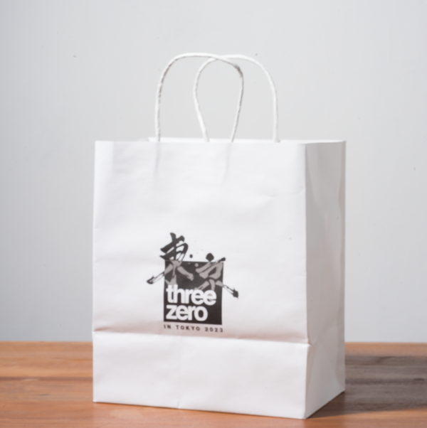 A mockup of a white kraft paper bag is displayed on a gray background with wood grain