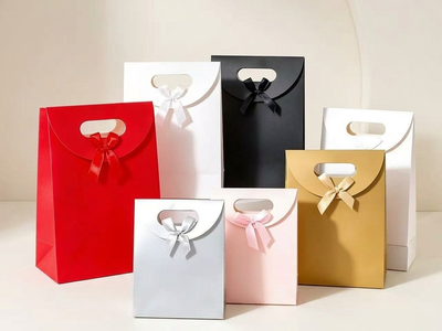 Assortment of seven premium paper gift bags in red, white, black, silver, pink, and gold with satin ribbon bows