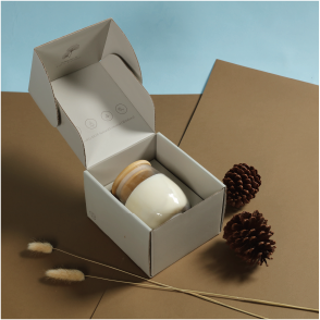 A candle glass jar is placed inside a mailing box