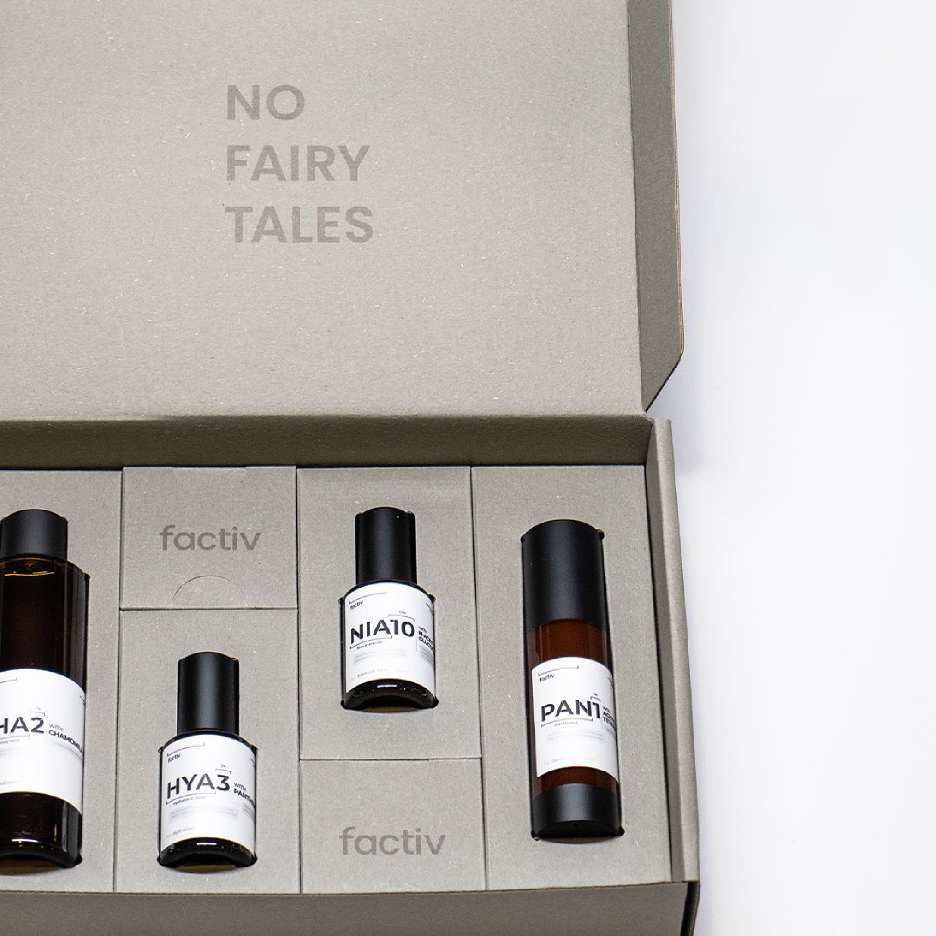 Inside a colorful mailing box are four bottles of different sizes.