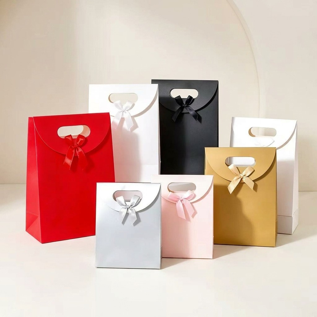 Assortment of seven premium paper gift bags in red, white, black, silver, pink, and gold with satin ribbon bows
